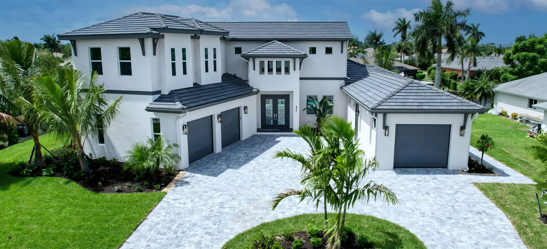 A large white house with a palm tree in the yard.