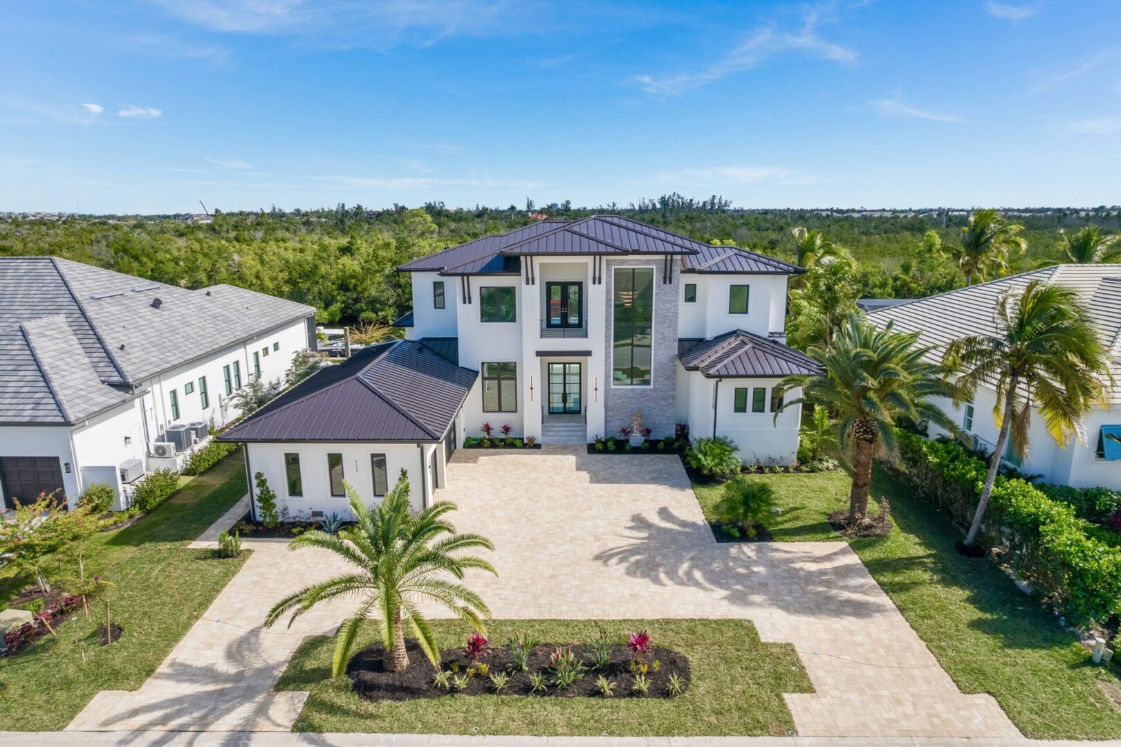 A large white house with palm trees in the background.