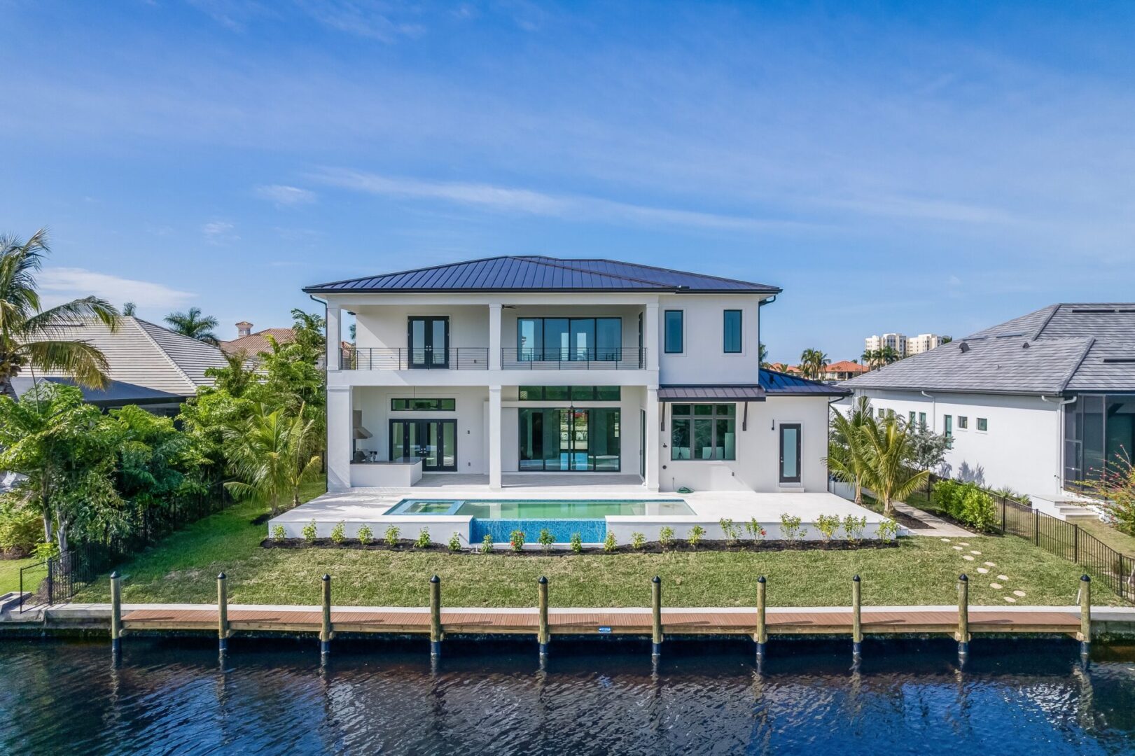 A large white house with a pool in the middle of it.